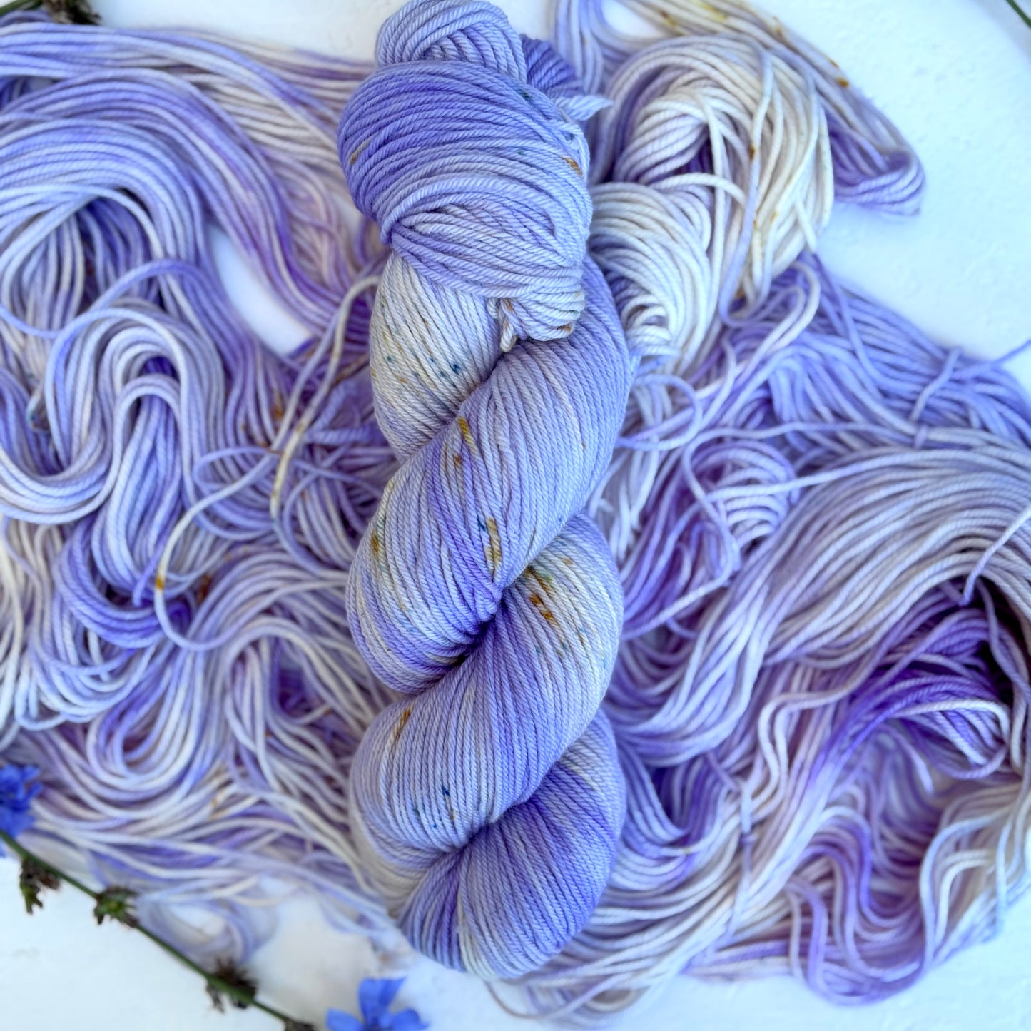 Bundles of purple and white yarn on a white background