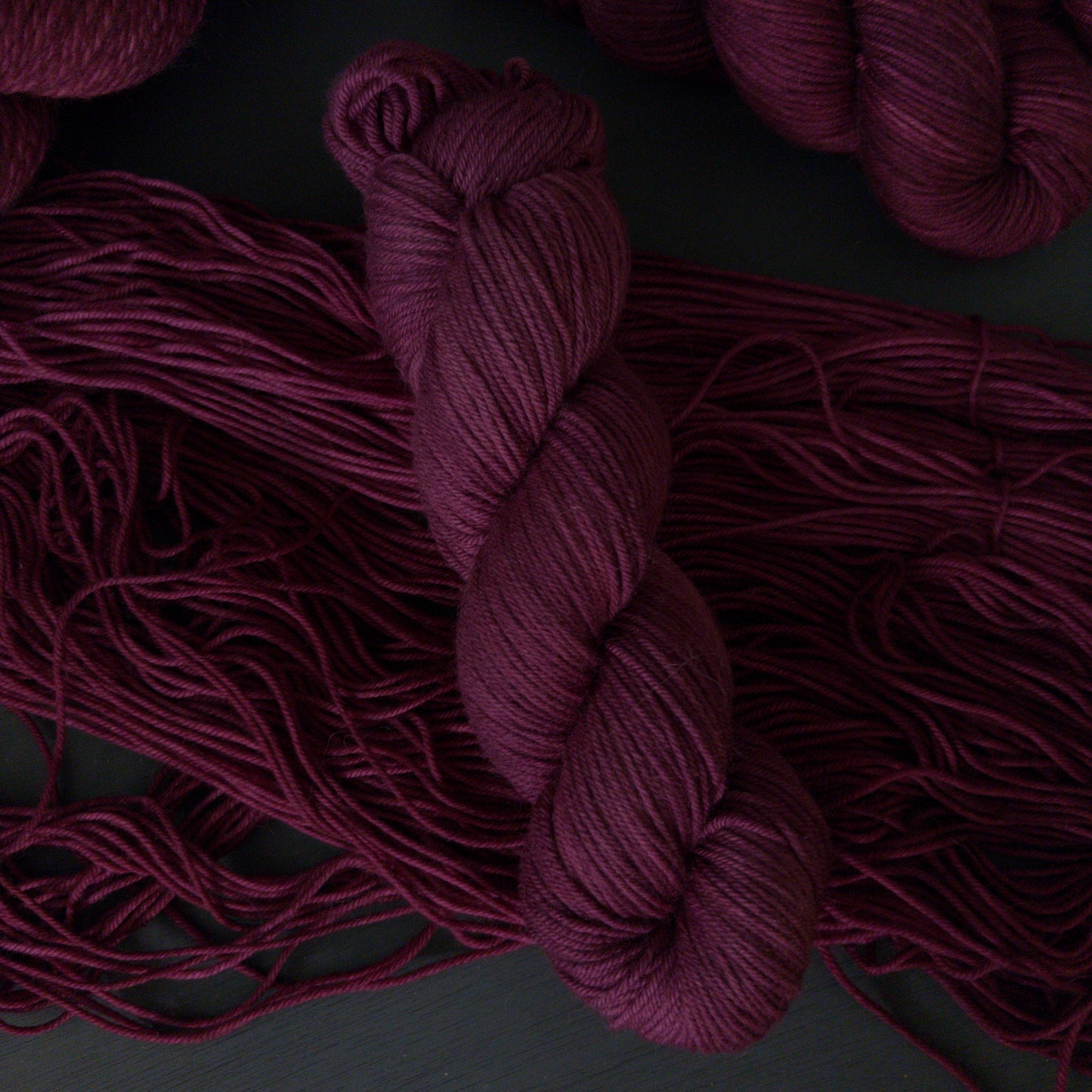 Close-up of burgundy yarn on a dark background