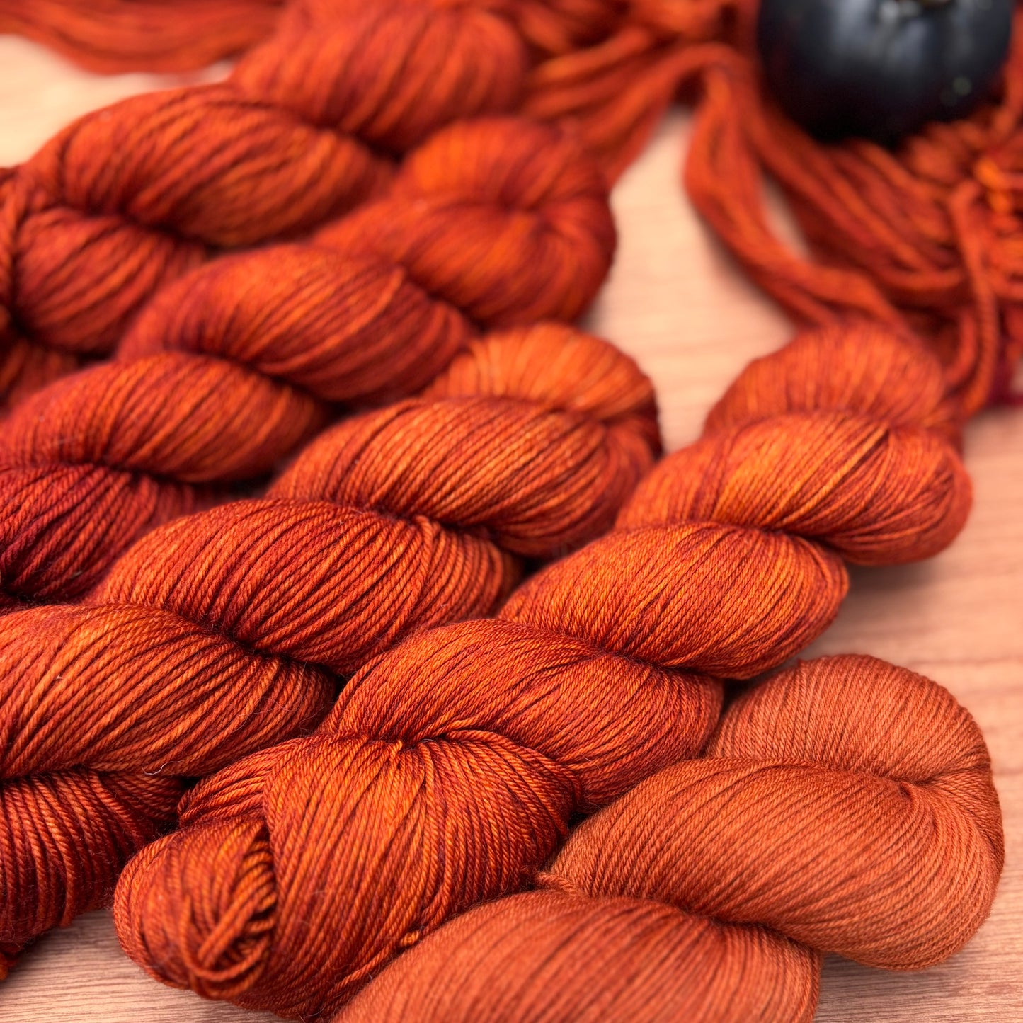 Close-up of orange yarn skeins on a wooden surface