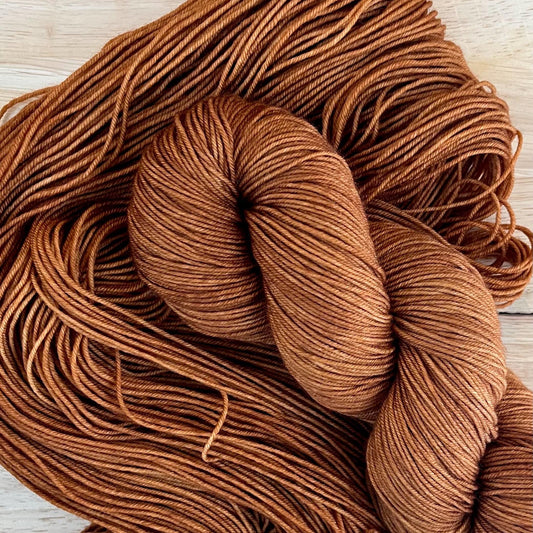 Skeins of hand dyed copper brown merino wool yarn