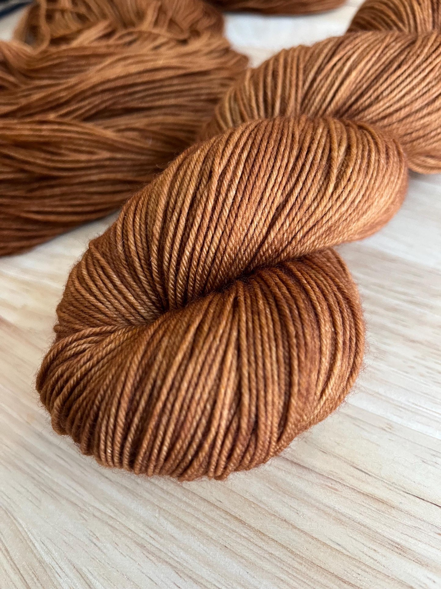 Skeins of sock weight hand dyed warm brown merino wool yarn