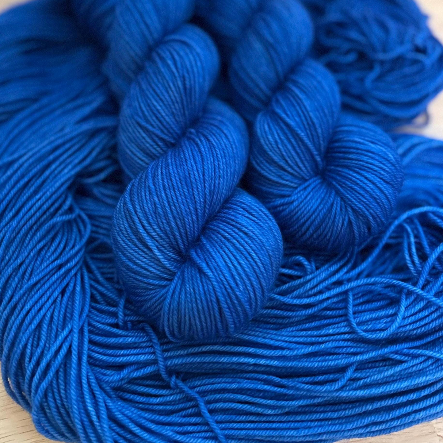 Blue yarn skeins on a wooden surface