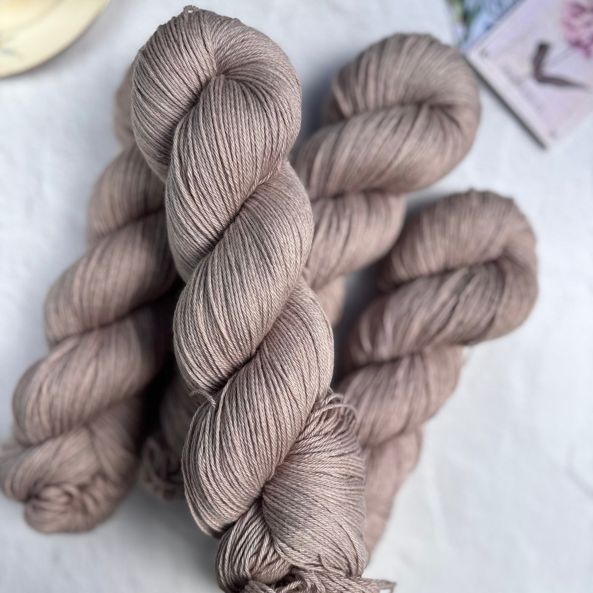 Skeins of beige yarn on a light surface with a blurred background