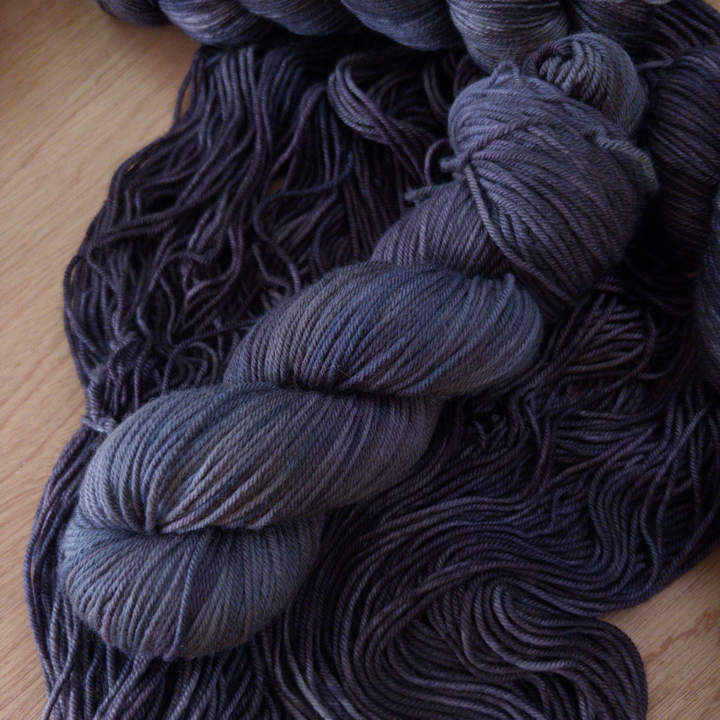 Dark gray wool yarn on a wooden surface