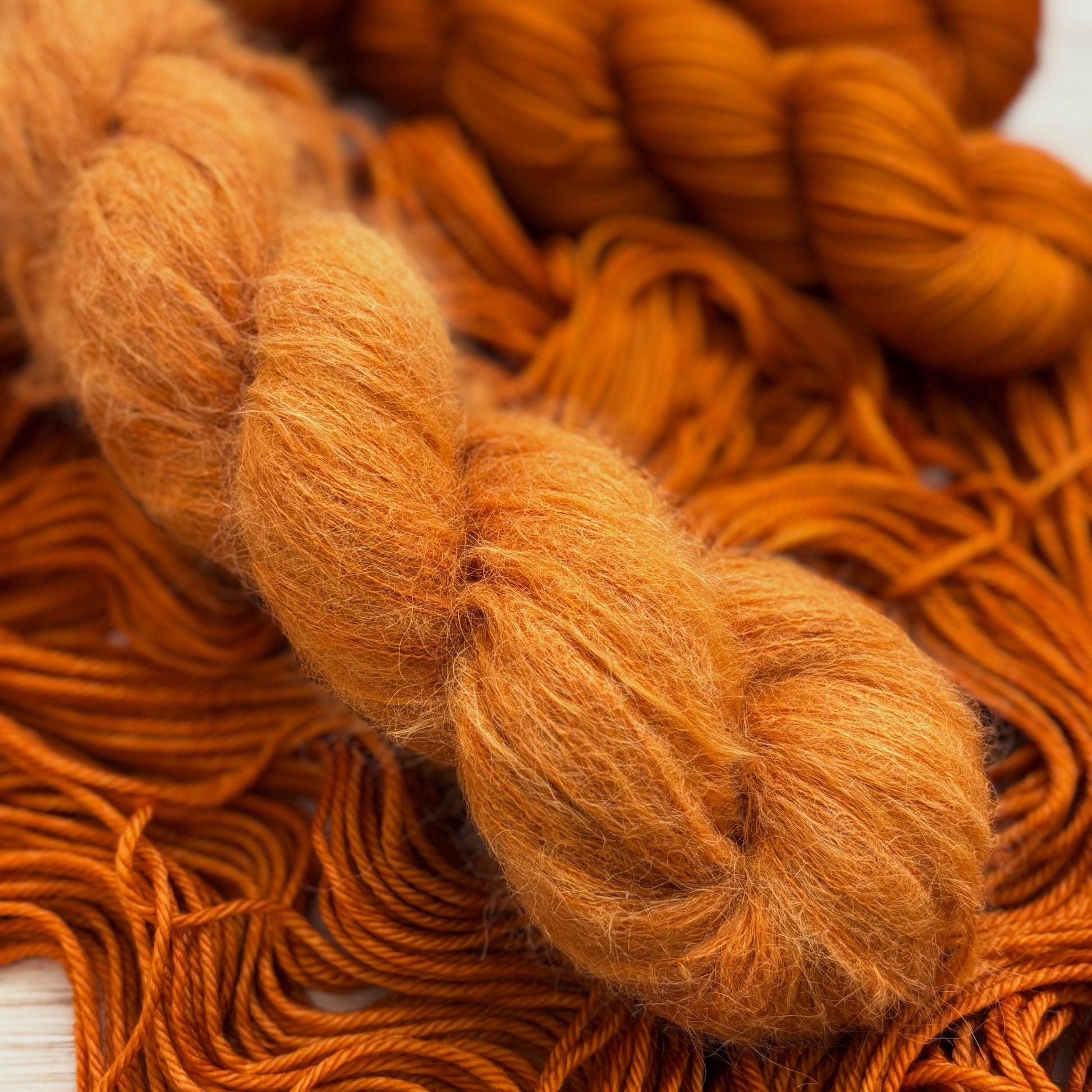 A skein of hand dyed alpaca yarn in a rust orange color.