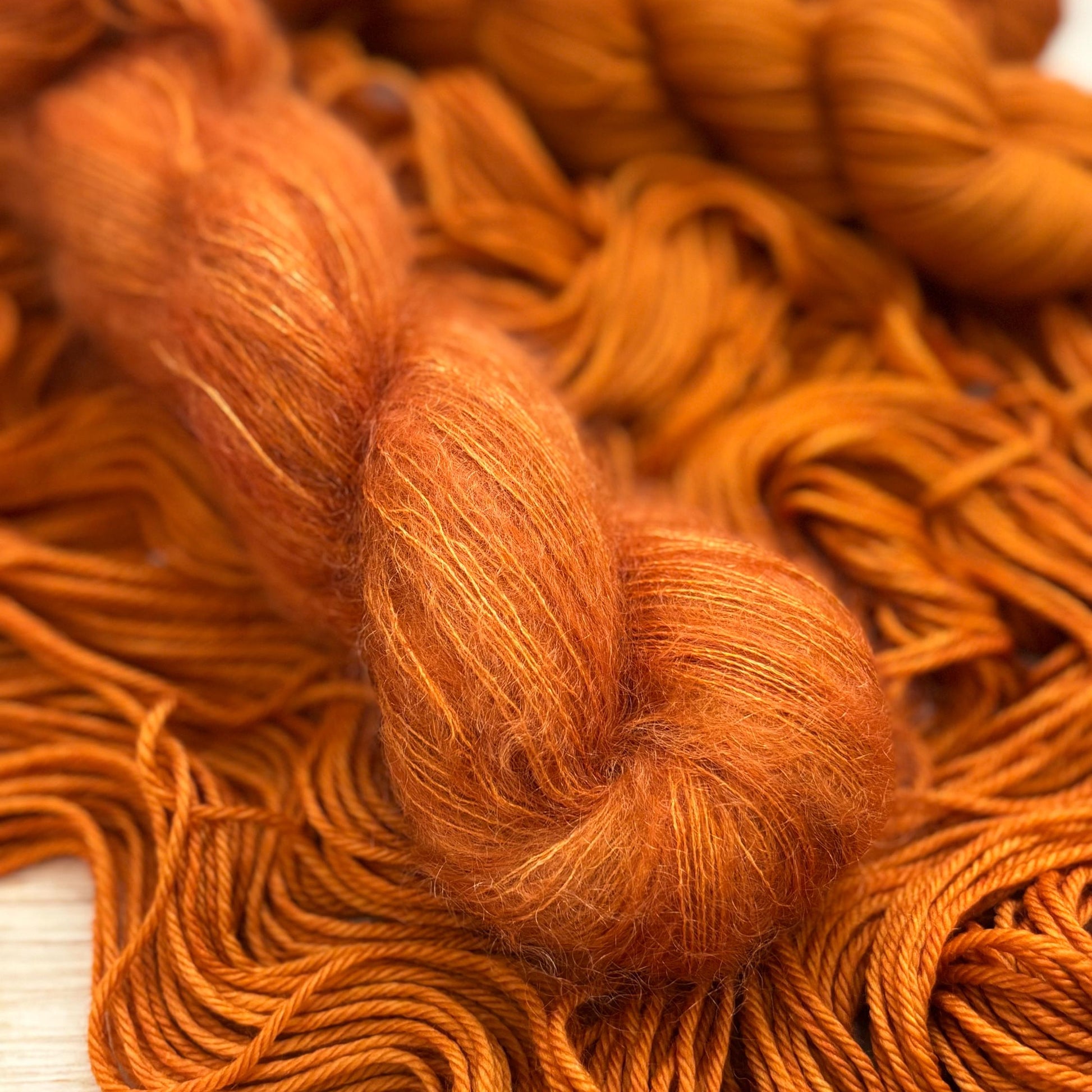 A skein of mohair lace yarn dyed a rust orange color.