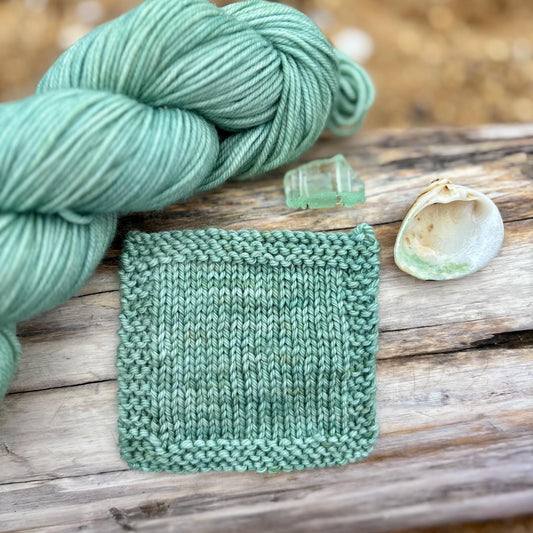 A knit swatch of aqua green yarn.
