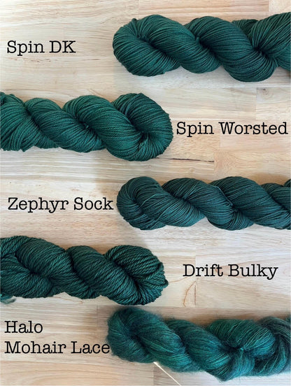 Examples of the Black Pine hand dyed dark forest green colorway on different yarn bases.  Bases include DK weight, worsted, sock, and bulky merino wool, and mohair lace.