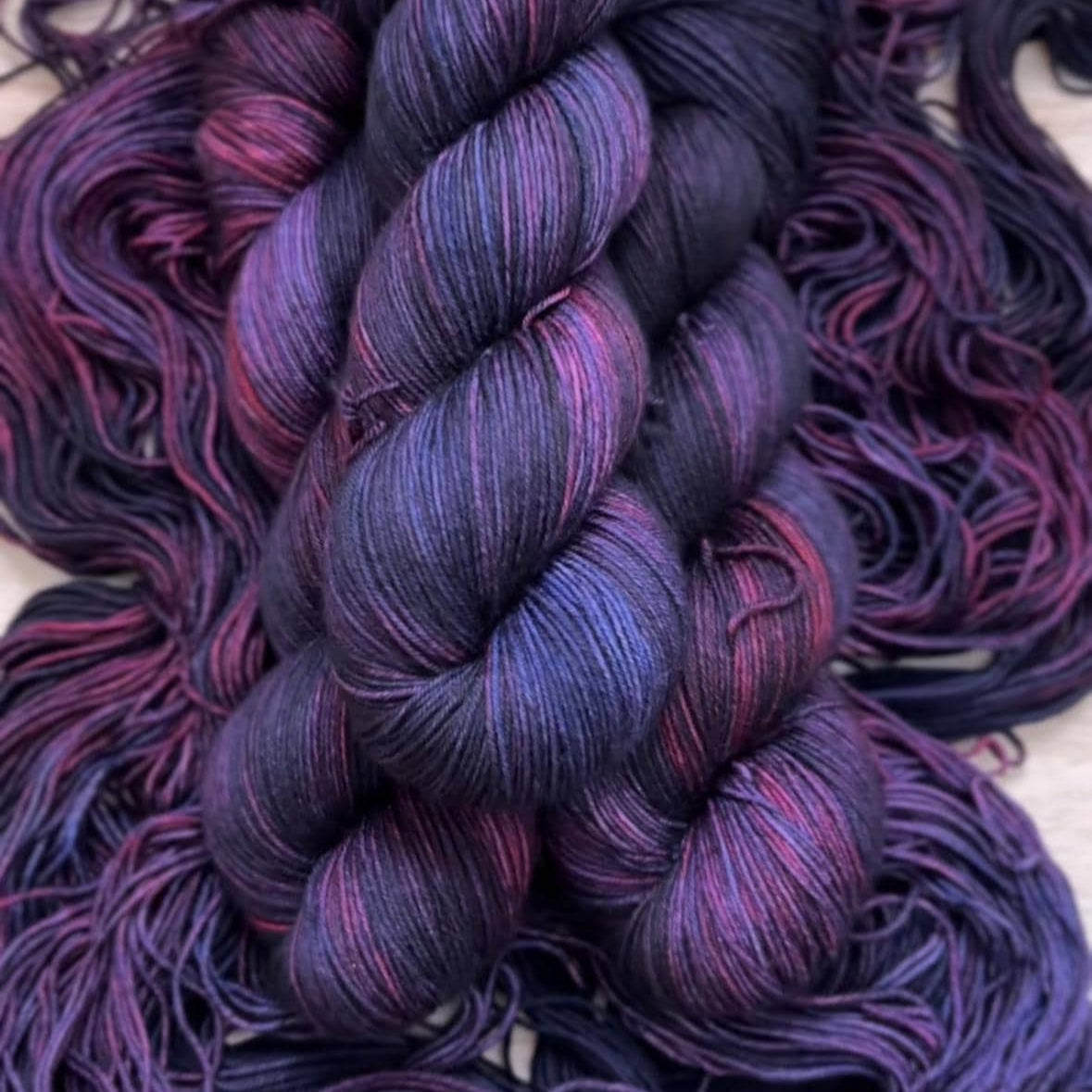 Skeins of dark purple and burgundy hand dyed yarn.