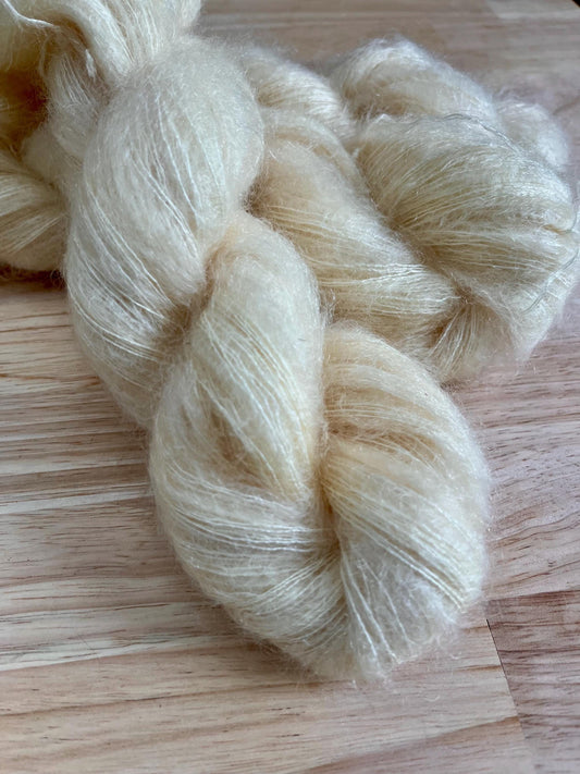 Skeins of creamy off white hand dyed mohair silk lace yarn.
