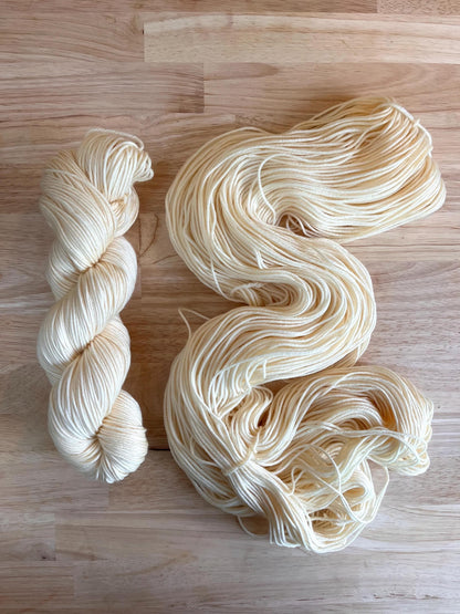 Skeins of creamy off white hand dyed merino wool yarn.