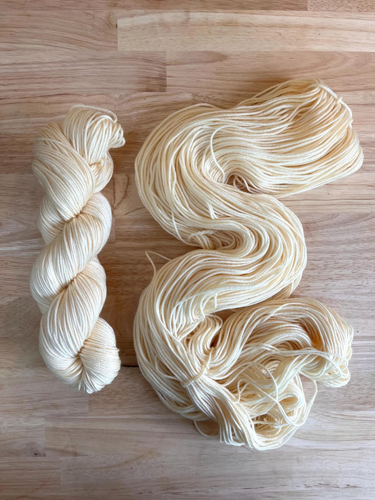 Skeins of creamy off white hand dyed merino wool yarn.
