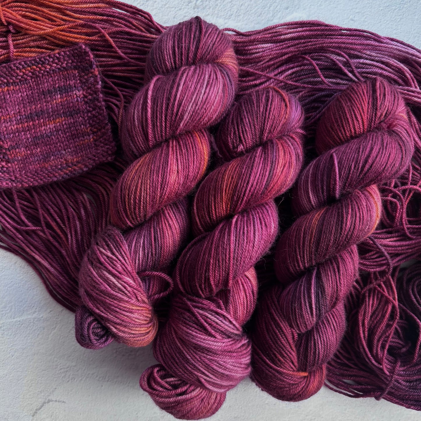 Balls of purple yarn on a light gray background