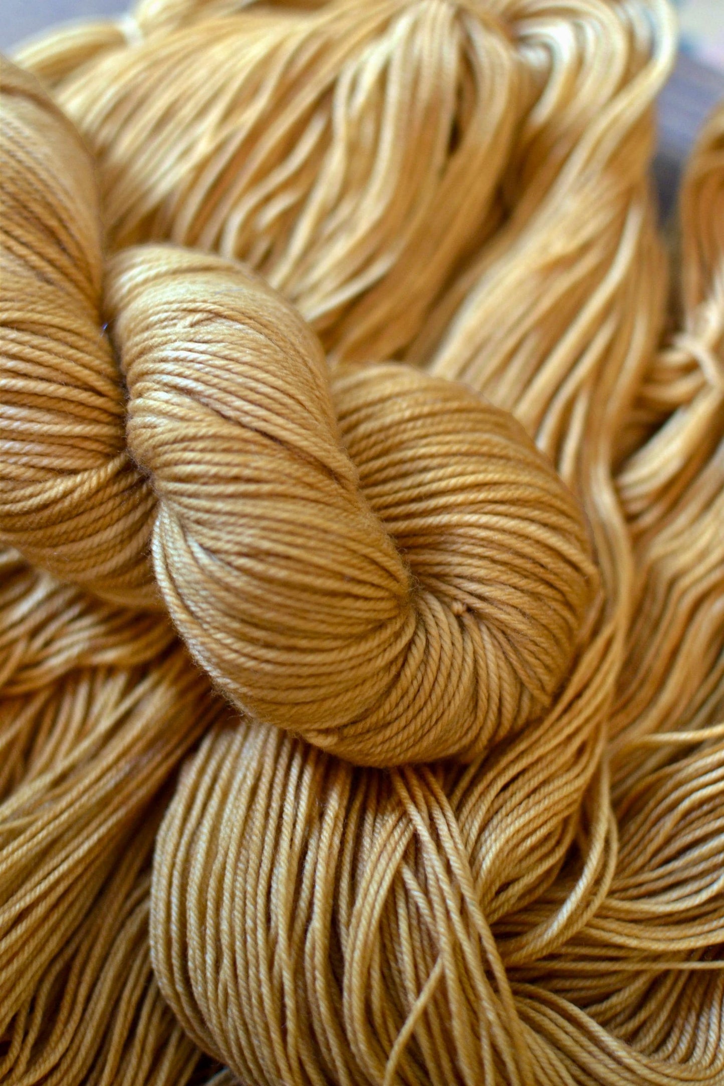 A skein of camel colored hand dyed merino wool yarn.