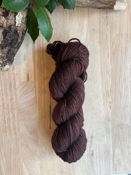 A skein of dark brown hand dyed merino wool yarn 