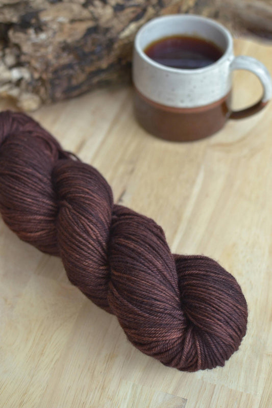 A skein of dark brown hand dyed merino wool yarn 