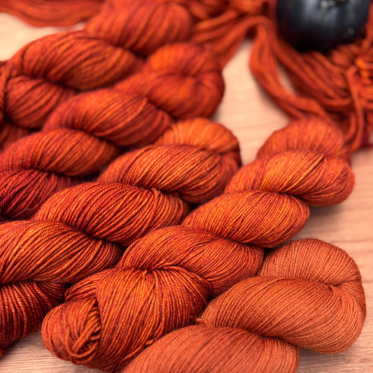 Close-up of orange yarn skeins on a wooden surface