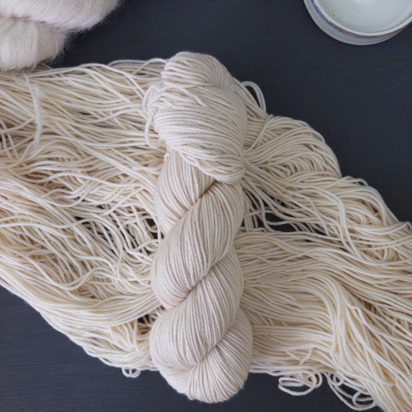 White skein of yarn on a dark surface