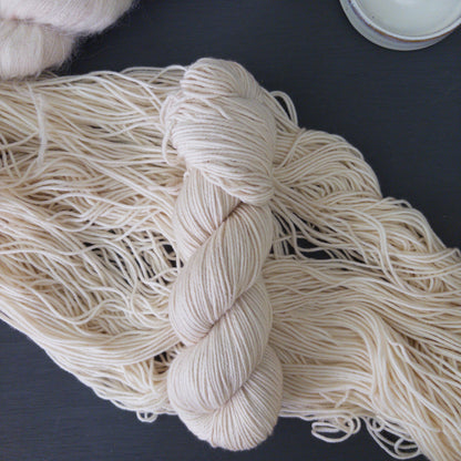 White skein of yarn on a dark surface