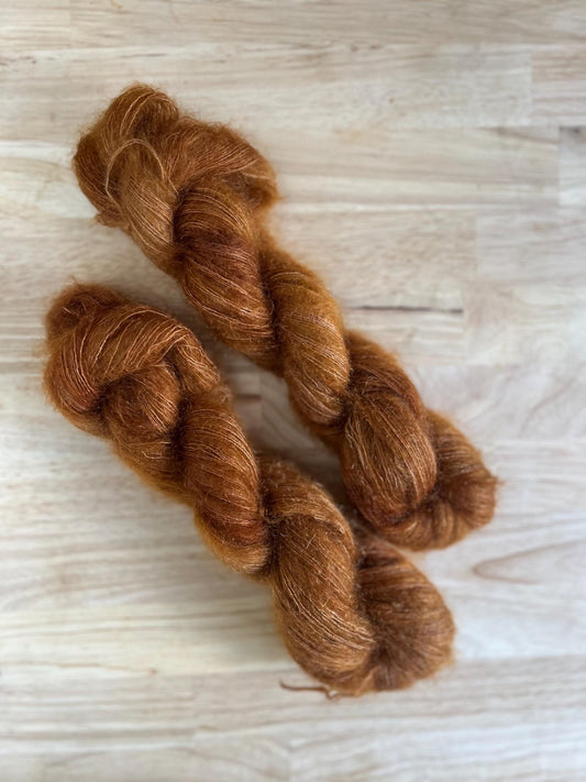 Skeins of hand dyed copper brown mohair silk lace weight yarn.