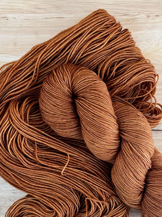 Skeins of hand dyed copper brown merino wool yarn
