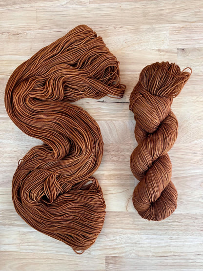 Skeins of hand dyed copper brown merino wool yarn