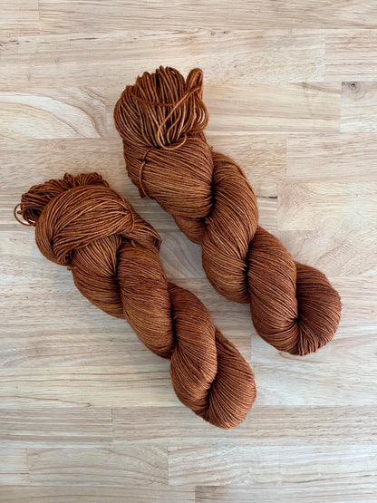 Skeins of hand dyed copper brown merino wool yarn