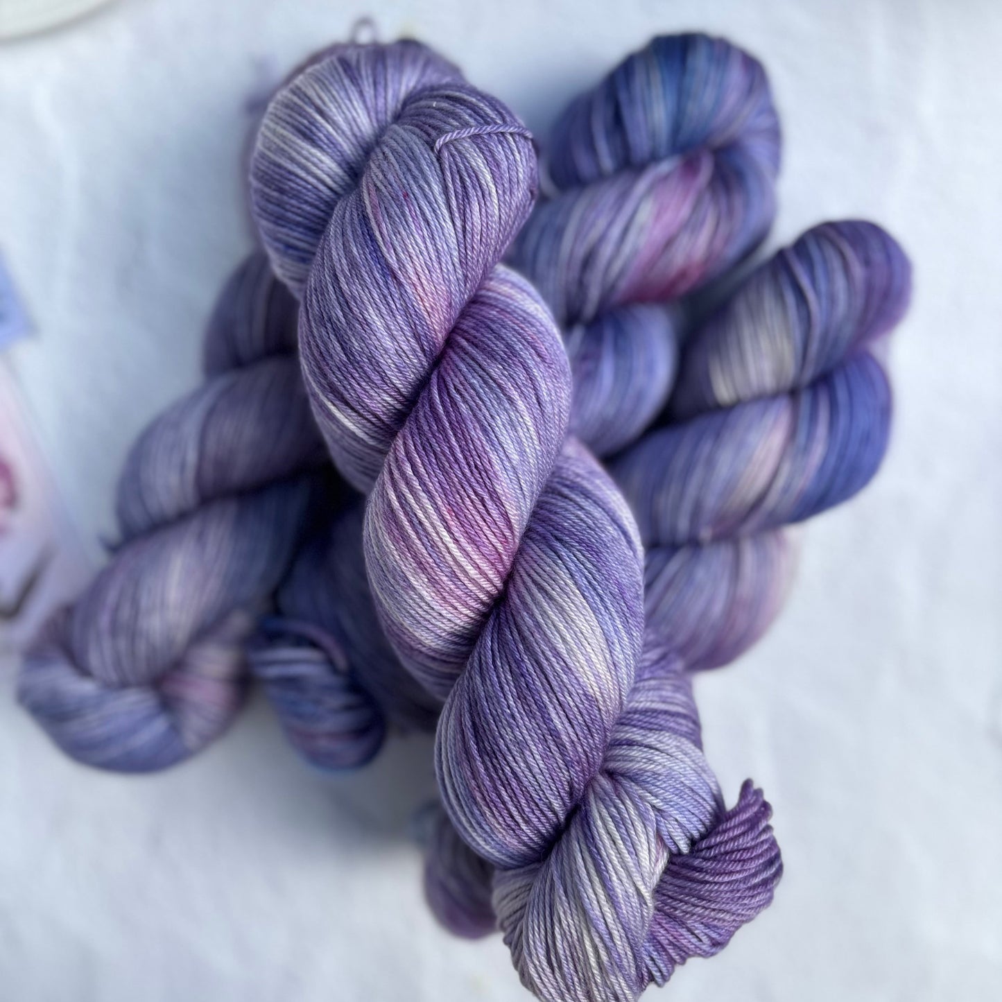 Three skeins of purple yarn on a light background