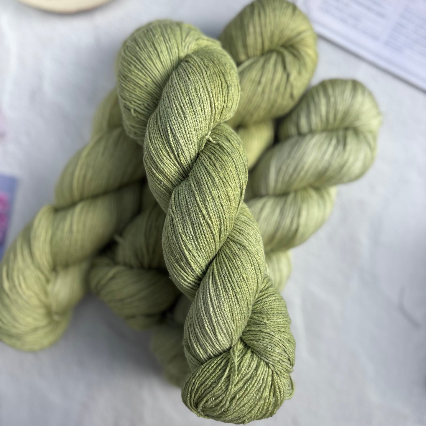 Skeins of green yarn on a white surface