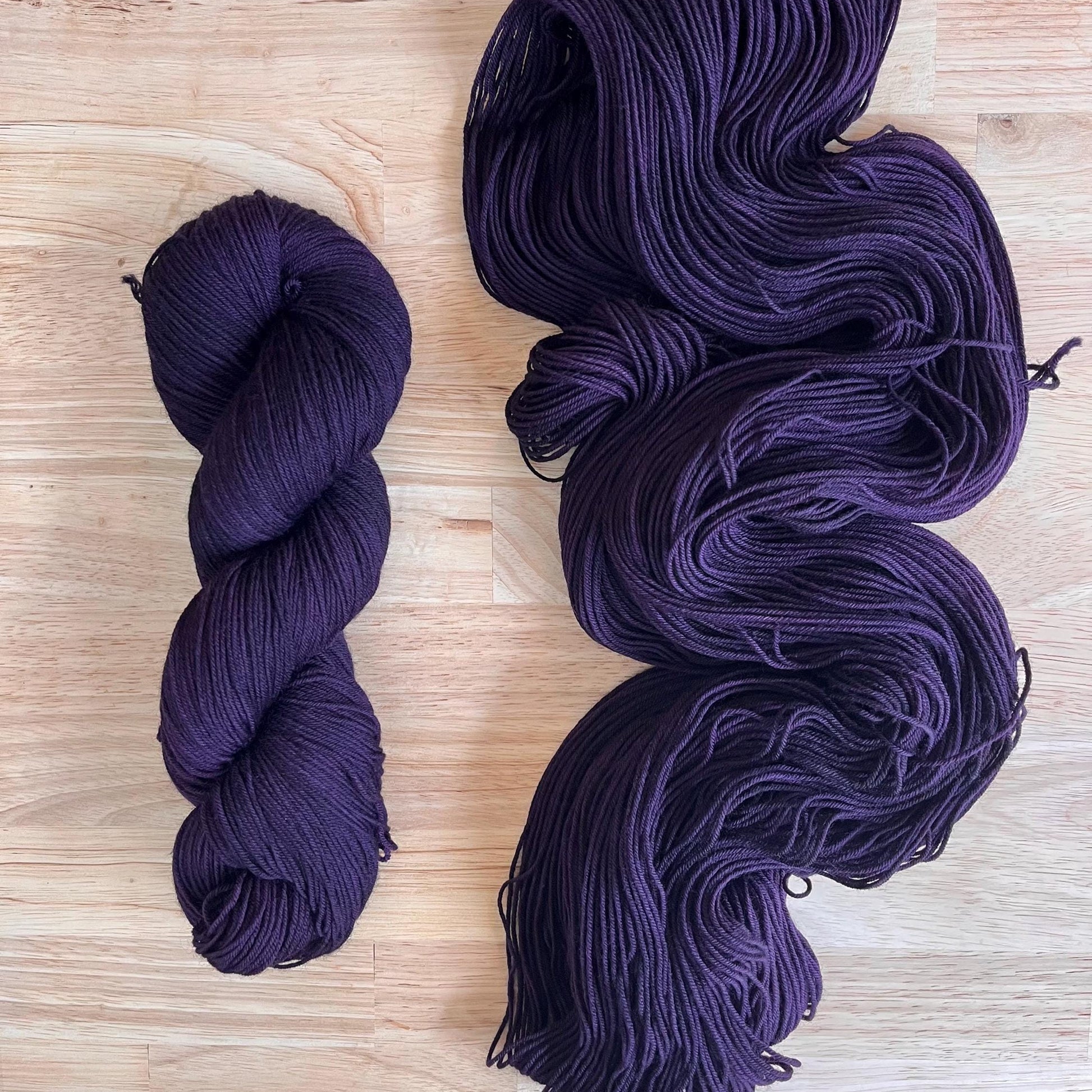 Skeins of hand dyed dark purple merino wool yarn 