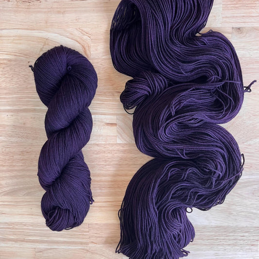 Skeins of hand dyed dark purple merino wool yarn 