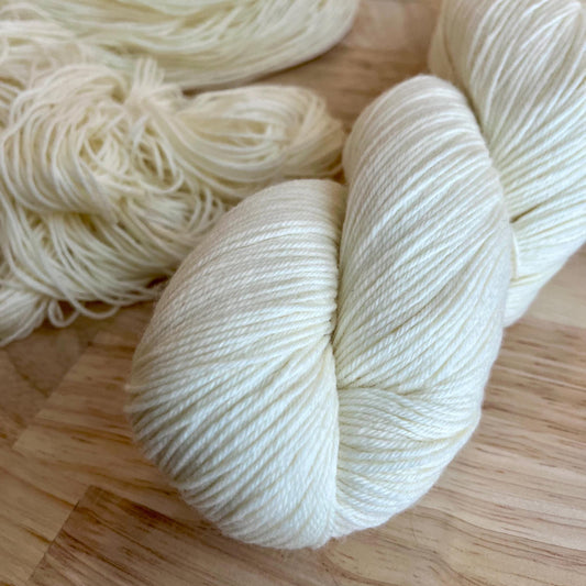 White yarn skeins on a wooden surface